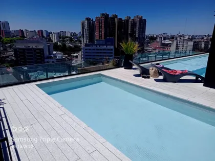Piscina de azotea con deck blanco y vistas a la ciudad — proyecto Obra Urquiza 1640, por Soluciones Bralum, en Buenos Aires
