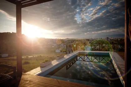 Piscina exterior con vista al atardecer y deck de madera — proyecto  Inmuebles, por Geo Estudio, en Buenos Aires