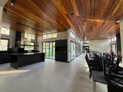 Cocina moderna con isla negra y techo de madera — proyecto Willy Nilly, por PS arq., en Cariló