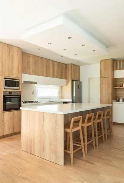 Cocina moderna con isla central, muebles de madera clara y detalles minimalistas — proyecto Reforma cocina , por Metro creativo , en Belén de Escobar