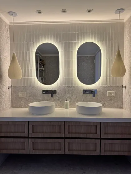 Baño moderno con doble bacha, espejos retroiluminados y luces colgantes — proyecto Lafinur, por MDBK Arquitectura, en Palermo