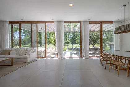 Living comedor moderno con ventanales amplios y vista al exterior — proyecto CASA BaCa, por Alfredo Orfila arquitectura, en Benavidez