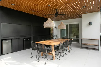 Comedor exterior moderno con techo de madera y sillas de metal — proyecto Obra Newman J, por Arq. Lourdes Yarade Saravia, en Benavidez