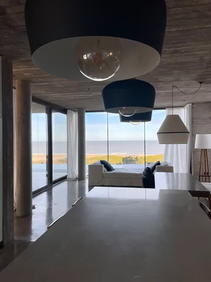 Living moderno con vista al mar y detalles de hormigón — proyecto CASA sobre el MAR, por Guerrero Arquitectos, en Pinamar
