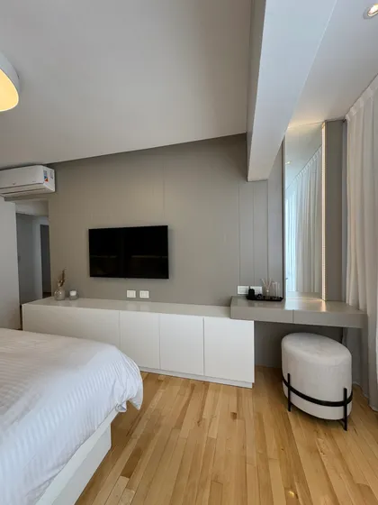 Dormitorio moderno con cama blanca, mueble bajo y tocador gris — proyecto Mendoza, por MDBK Arquitectura, en Belgrano