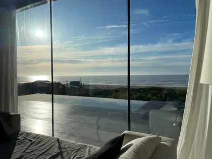 Dormitorio moderno con vista al mar y ventanales — proyecto CASA sobre el MAR, por Guerrero Arquitectos, en Pinamar