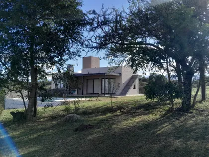 Fachada moderna rústica con ladrillo, madera y grandes ventanales — proyecto Complejo de Cabañas en Potrero de Garay, Córdoba, por ESTUDIO ARQ.GABRIEL ARIAS, en Córdoba