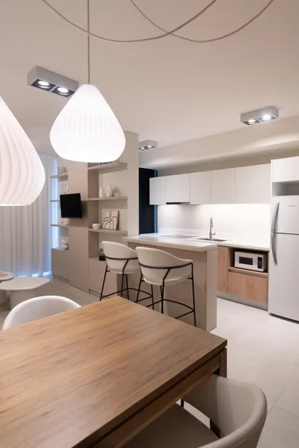 Cocina moderna abierta con isla, barra y mesa de comedor de madera — proyecto EVOQUE, por MB Díseño Interior , en Buenos Aires