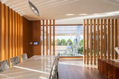 Pasillo moderno con revestimiento madera, ventanal luminoso y doble altura — proyecto Arquitectura de Autor, por Ciba Arquitectura