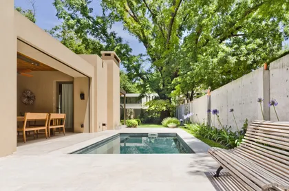 Piscina moderna rodeada de vegetación exuberante — proyecto Casa P, por Estudio Dado, en San Isidro