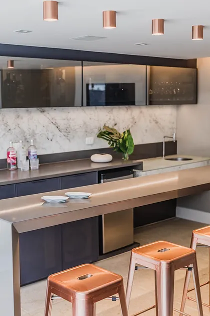 Cocina moderna con isla de madera, marmol blanco y detalles cobre — proyecto Casa Barra ED, por Amanda Miranda