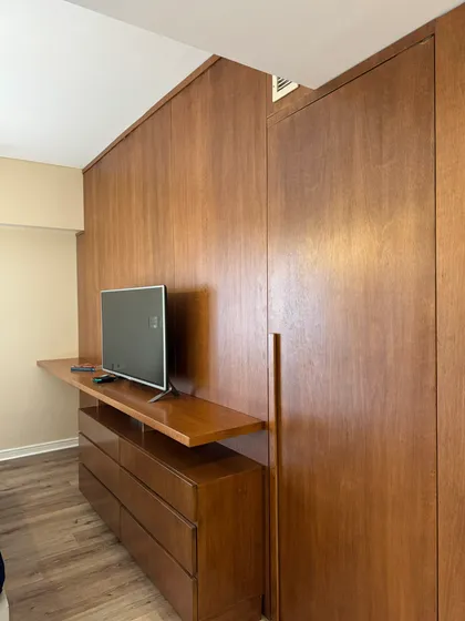 Dormitorio con paneles de madera, mueble bajo y TV — proyecto Coronel Diaz, por MDBK Arquitectura, en Palermo