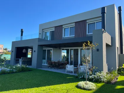 Fachada moderna con patio, césped y detalles de madera — proyecto SAN MATIAS II, por Fb Arqs, en Belén de Escobar