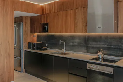 Cocina moderna con isla central y revestimiento de madera — proyecto Quartier - Estudio CCWay, por ABEJA CONCEPT, en Palermo