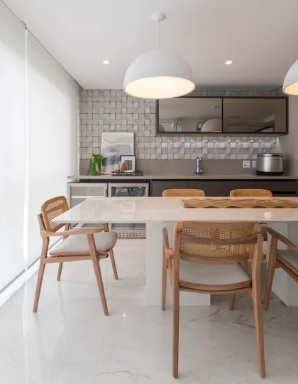 Comedor moderno con cocina integrada, mesa de mármol y sillas de ratán — proyecto Projeto Destaque Club&Casa, por Studio HA