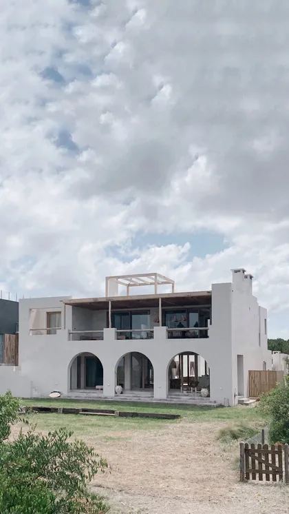 Casa blanca moderna con arcos frente al mar — proyecto El Refugio, por Grupo Pauta Arquitectura, en Pinamar