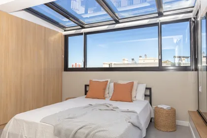 Dormitorio moderno con techo de tragaluz y pared de madera — proyecto Viamonte II, por WA arquitectura, en CABA