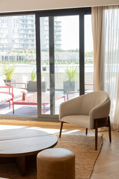 Living moderno con terraza y sillón curvo — proyecto Pia Magri, por Gaby Alfonso, en B1648 Tigre