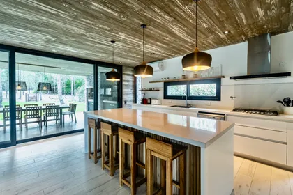 Cocina comedor moderna rústica con isla y techo de madera — proyecto casa la huella, por Guerrero Arquitectos, en Pinamar