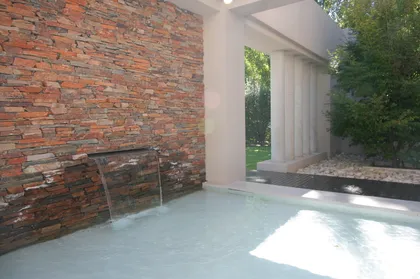 Piscina moderna con pared de piedra y cascada — proyecto  Inmuebles, por Geo Estudio, en Buenos Aires