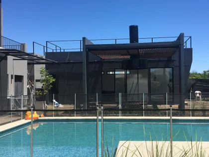 Fachada moderna con piscina y elementos de madera — proyecto Ecobox , por Steel framing panel, en Pilar