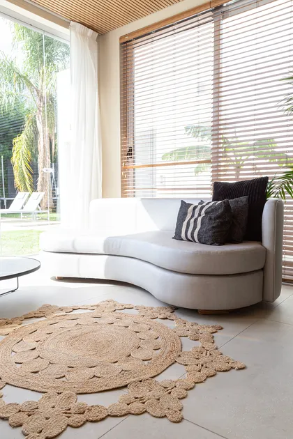 Sala de estar moderna con sofá curvo blanco y alfombra de yute — proyecto Proyecto Gaby P. , por LINEA NETA diseño interior , en Canning