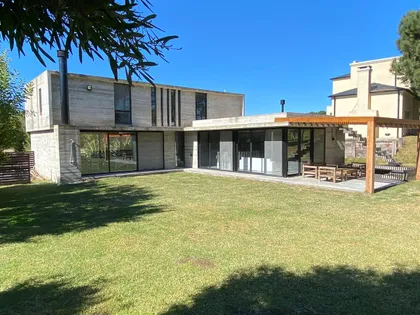 Fachada moderna de concreto con amplios ventanales y patio — proyecto Casa R2, por Guerrero Arquitectos, en Pinamar