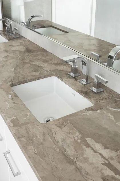 Baño moderno con doble lavabo, encimera de piedra y grifería cromada — proyecto REFORMA GDLT, por Rastro Estudio, en Nordelta