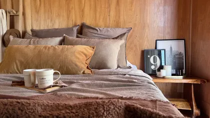 Dormitorio rústico con pared de lamas de madera y cama amplia — proyecto Tierra Habano./03, por Mara Fuhr, en Núñez