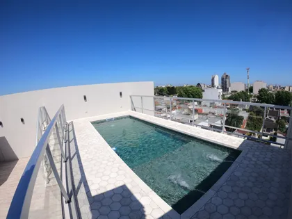 Piscina de azotea con vistas urbanas y cielo despejado — proyecto Juan Agustín García 5154, por CIFARELLI arquitectos, en Buenos Aires