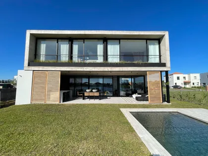 Casa moderna con fachada de hormigón y grandes ventanales — proyecto El Secreto, por Grupo Pauta Arquitectura, en Tigre