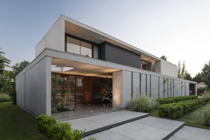 fachada de casa moderna con volúmenes de hormigón y amplios ventanales — proyecto Casa Martindale, por Ezequiel Amado Cattaneo - EAC, en Martindale Country Club
