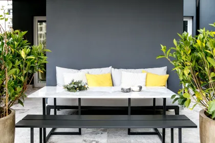 Patio moderno con muebles negros y vegetación exuberante — proyecto BA 2 2019, por Mesopotamia Ba, en CABA