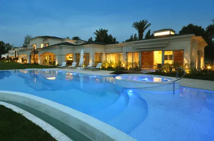 Villa moderna con piscina infinita al atardecer — proyecto Conjunto Neoclásico Familiar, por Apaarquitectura