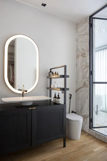 Bano moderno con espejo ovalado iluminado y mueble negro — proyecto BM House, por Studio Ro-ca