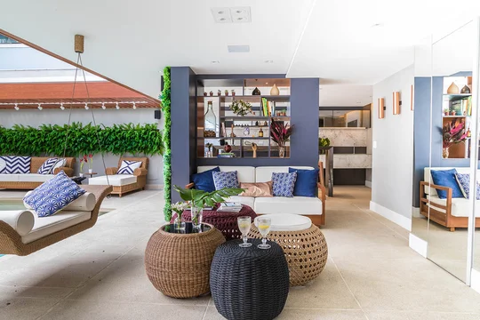 Living moderno con jardín vertical, muebles de ratán y paleta azul blanca — proyecto Casa Barra ED, por Amanda Miranda