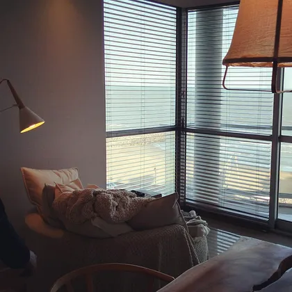 Living comedor con vista al mar y sillón cómodo — proyecto Departamento MH, por Vicky Hurrell, en Mar del Plata