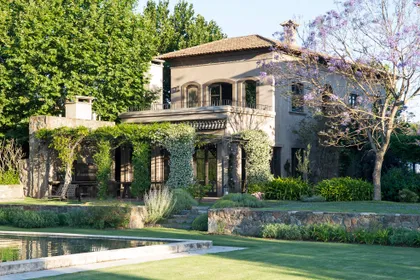 Villa mediterranea con pileta frontal, fachada cubierta hiedra verde — proyecto Casa Toscana , por Estudio Du 