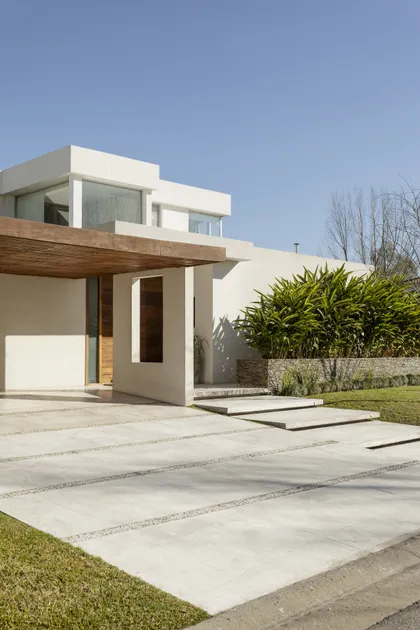 Casa moderna blanca con pergola de madera y patio de hormigón pulido — proyecto Santa Barbara 121, por Build a Home Arquitectura, en B1648 Tigre
