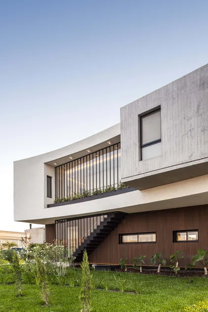 Casa moderna de dos niveles con hormigón y madera, escalera exterior metálica — proyecto Estudio ABS. Arqs. Butler / Saal, por alejandroperalphotography