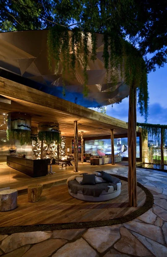 Quincho moderno con deck de madera, hogar circular y enramada iluminada — proyecto Arquitetura e Interiores II, por Demian Golovaty