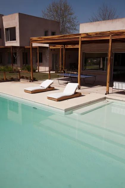 Área de piscina moderna con tumbonas y pérgola de madera — proyecto  Inmuebles, por Geo Estudio, en Buenos Aires