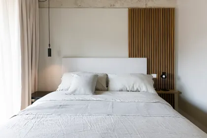 Dormitorio moderno con pared de listones de madera y cama blanca — proyecto Nicaragua, por SRMD Arquitectura, en Palermo