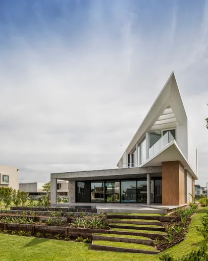 fachada moderna con techo geométrico y jardín escalonado — proyecto Casa Didney, por Jorgelina Tortorici & asoc., en Nordelta