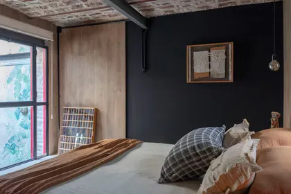 Habitación con pared de ladrillos expuestos y detalles en madera — proyecto Casa Arcos, por Silvia Soqueff, en Núñez