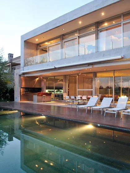 Casa moderna con piscina y sillones blancos — proyecto Casa AB, por Santiago Cordeyro Arquitectos, en Nordelta