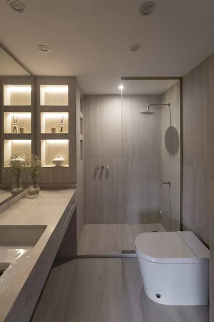 Baño moderno con estantes iluminados y superficies de piedra — proyecto Libertador, por Bouré Studio, en Palermo