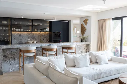 Cocina moderna integrada a living, isla de mármol y sofá beige — proyecto Pia Magri, por Gaby Alfonso, en B1648 Tigre