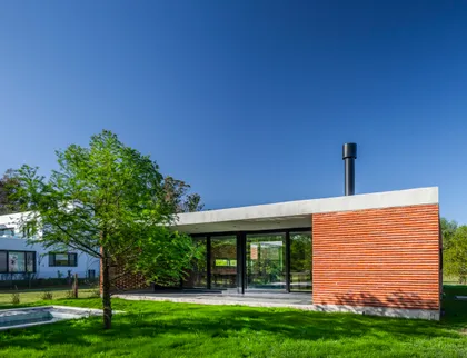 Casa moderna con fachada de ladrillo visto y grandes ventanales — proyecto Casa FLOIG, por V2 Arquitectos, en Villa Elisa