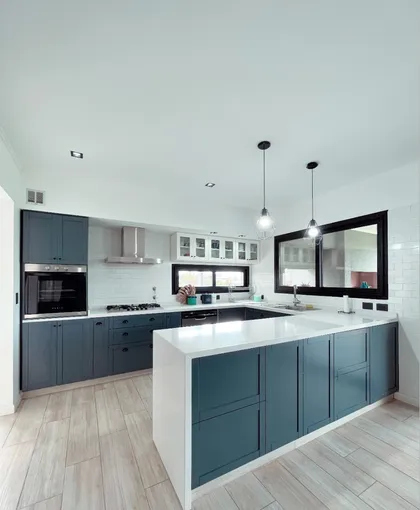 Cocina moderna con isla azul oscuro y mesada blanca — proyecto Casa A.M., por Arcucci Arquitectura, en Belén de Escobar